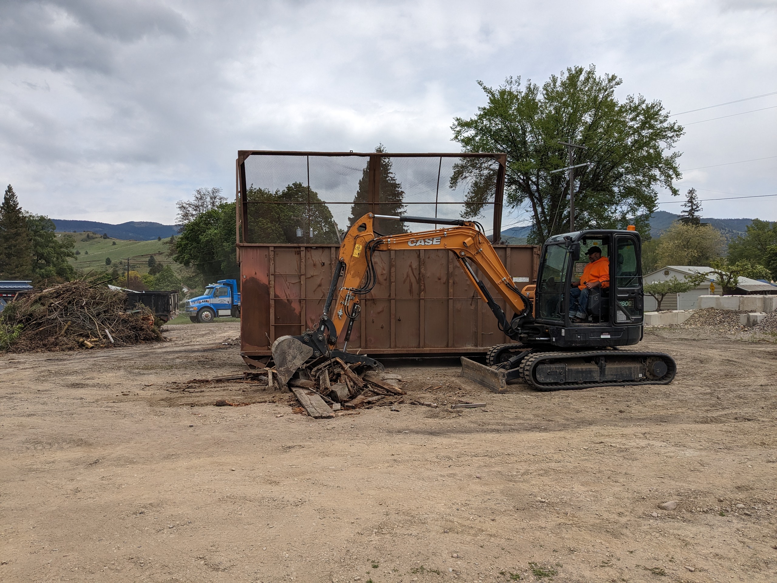 Trucks and trailers loaded with tires and scrap, mountains in the distance